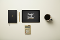 Profit on a Budget ebook flat-lay with tablet, matte-black notebook, gold pen, calculator and coffee cup on ivory background